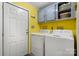 Bright laundry room with yellow walls, cabinets above, a dryer and a modern washing machine at 2003 Cape Hickory Cutoff Rd, Hickory, NC 28601