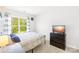 Bright bedroom featuring a comfortable bed, large window, and a modern TV on a dark wood dresser at 2115 Sonoma Valley Dr, Charlotte, NC 28214