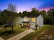 Charming two-story home with gray siding, a black roof, and manicured landscaping against a twilight sky at 2115 Sonoma Valley Dr, Charlotte, NC 28214