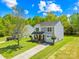 Charming two-story home with gray siding, a black roof, and manicured landscaping on a beautiful sunny day at 2115 Sonoma Valley Dr, Charlotte, NC 28214