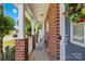 Inviting front porch featuring brick accents, white columns, and a cozy seating area near a gray front door at 2115 Sonoma Valley Dr, Charlotte, NC 28214