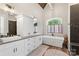 Bright bathroom features white cabinetry, and a soaking tub under an arched window at 220 Palm Cove Way, York, SC 29745