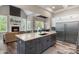 Spacious kitchen with a large island, stainless steel appliances, and an adjoining living area with fireplace at 220 Palm Cove Way, York, SC 29745