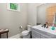 Clean powder room with modern vanity, mirror, toilet, and natural light from a small window at 220 Palm Cove Way, York, SC 29745