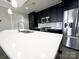Modern kitchen island with white countertops, sink and stainless steel appliances at 222 S Caldwell St # 1801, Charlotte, NC 28202