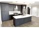Modern kitchen featuring stainless steel appliances, island with white countertops and dark wood cabinets at 222 S Caldwell St # 1801, Charlotte, NC 28202