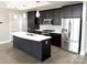 Modern kitchen featuring stainless steel appliances, island with white countertops and dark wood cabinets at 222 S Caldwell St # 1801, Charlotte, NC 28202