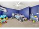 Inviting bedroom with blue accent wall, carpeted floor, ceiling fan, and a variety of colorful toys at 2262 Galloway Sw Ln, Concord, NC 28025