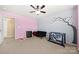 Bright bedroom featuring neutral carpet, pink accent wall, and a whimsical tree mural at 2262 Galloway Sw Ln, Concord, NC 28025