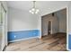 Light-filled dining area featuring a modern chandelier, wood floors, and seamless flow into adjacent rooms at 2290 Kestrel Dr, Rock Hill, SC 29732