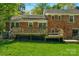 View of home's brick exterior with a spacious wooden deck, offering a perfect spot for relaxation and entertaining at 2815 Burnt Mill Rd, Charlotte, NC 28210