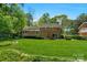 Lush backyard featuring a well-maintained lawn, brick house, and mature trees at 2815 Burnt Mill Rd, Charlotte, NC 28210