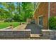 Exterior view of a brick home featuring a stone patio, wooden deck, and spacious backyard at 2815 Burnt Mill Rd, Charlotte, NC 28210