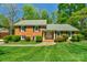 Charming brick home featuring a well-manicured lawn and lush landscaping, creating an inviting curb appeal at 2815 Burnt Mill Rd, Charlotte, NC 28210