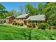 Charming brick home featuring a well-manicured lawn and lush landscaping, nestled on a beautiful lot at 2815 Burnt Mill Rd, Charlotte, NC 28210