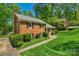 Well-maintained brick home surrounded by lush greenery and manicured landscaping at 2815 Burnt Mill Rd, Charlotte, NC 28210