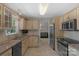 Well-lit kitchen featuring light wood cabinets, stainless steel appliances, tile flooring, and a view into the adjacent living room at 2815 Burnt Mill Rd, Charlotte, NC 28210
