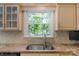 Bright kitchen sink under a window with natural light and neutral countertops, cabinets, and backsplash tiles at 2815 Burnt Mill Rd, Charlotte, NC 28210