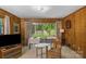 Living room featuring wood paneling and sliding glass doors to the backyard at 2815 Burnt Mill Rd, Charlotte, NC 28210