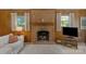 Living room with brick fireplace and windows, and wood paneling at 2815 Burnt Mill Rd, Charlotte, NC 28210
