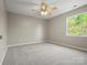 Comfortable bedroom showcasing neutral walls, carpet, a ceiling fan, and a window with natural light at 3002 Fair Meadows Dr, Monroe, NC 28110