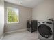Bright laundry room features tile flooring, a window, and modern, front-load washer and dryer set at 3002 Fair Meadows Dr, Monroe, NC 28110