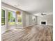 Open-concept living room with a charming fireplace and plenty of natural light through bay windows at 3002 Fair Meadows Dr, Monroe, NC 28110