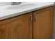 Close-up of a bathroom vanity with a white countertop and wood-finished cabinets at 3002 Fair Meadows Dr, Monroe, NC 28110