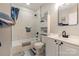 Bathroom features a shower-tub with a white tile surround and a white vanity with black hardware at 303 S Iredell Ave, Spencer, NC 28159