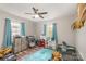 Bright bedroom with laminate floors, a ceiling fan and natural light from the two windows at 303 S Iredell Ave, Spencer, NC 28159
