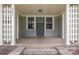 Inviting front porch with gray door and wood flooring, framed by white columns and number signage at 303 S Iredell Ave, Spencer, NC 28159