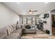 Inviting living room with a large gray sectional sofa, wood floors, and natural light streaming through the windows at 303 S Iredell Ave, Spencer, NC 28159