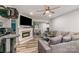 Cozy living room featuring a modern fireplace, ceiling fan, and comfortable gray sofa with stylish pillows at 303 S Iredell Ave, Spencer, NC 28159