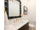 Stylish powder room featuring a black framed mirror, gold fixtures, and modern decor at 3473 Willow Oak Rd, Charlotte, NC 28209