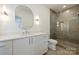 Bright bathroom with white vanity, oval mirror, modern lighting and glass enclosed shower at 3473 Willow Oak Rd, Charlotte, NC 28209