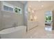 Bright bathroom featuring a soaking tub, double vanity and modern finishes at 3473 Willow Oak Rd, Charlotte, NC 28209