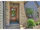 Inviting front entry with a wooden door, brick surround, house number, and decorative wreath at 3473 Willow Oak Rd, Charlotte, NC 28209