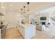 Spacious living area adjacent to kitchen featuring a fireplace, modern lighting, and open floor plan at 3473 Willow Oak Rd, Charlotte, NC 28209