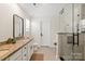 Bathroom features a double sink vanity with granite counters, white cabinets, tile floors, and a glass shower at 3637 Allenby Pl, Monroe, NC 28110