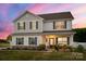 Charming two-story home with stone accents, gray shutters, and a manicured lawn under a colorful sky at 3637 Allenby Pl, Monroe, NC 28110