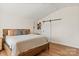 Spacious main bedroom features a sliding barn door, hardwood floors, neutral walls, and modern decor at 3637 Allenby Pl, Monroe, NC 28110
