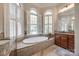 Elegant bathroom with a large soaking tub, arched windows, and custom vanity at 364 Stone Cliff Ln, Clover, SC 29710