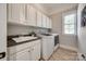 Well-lit laundry room with a sink, ample storage, and modern washer and dryer units at 364 Stone Cliff Ln, Clover, SC 29710