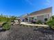Exterior view of a backyard featuring manicured landscaping, a gravel path and outdoor seating area at 4012 Moxie Way, Charlotte, NC 28215