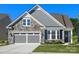 Charming home featuring a stone and gray siding exterior with a two-car garage and well-manicured lawn at 4012 Moxie Way, Charlotte, NC 28215