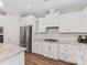 This kitchen features white cabinets, granite countertops, a stainless steel refrigerator, and a decorative backsplash at 4012 Moxie Way, Charlotte, NC 28215