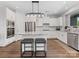 Bright kitchen features white cabinetry, stainless steel appliances, granite countertops, and a central island with barstool seating at 4012 Moxie Way, Charlotte, NC 28215