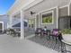 Cozy covered patio with seating area, black and white rug, and a view of the well-maintained backyard at 4012 Moxie Way, Charlotte, NC 28215