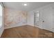 Bright bedroom boasts hardwood floors and floral accent wall at 4019 Plaza Row Ct, Charlotte, NC 28205