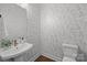 Stylish powder room featuring unique patterned wallpaper, a pedestal sink, and modern fixtures for a sophisticated touch at 4019 Plaza Row Ct, Charlotte, NC 28205